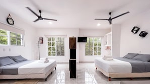 Une chambre d’hôtel moderne avec deux lits, une télévision et de grandes fenêtres.