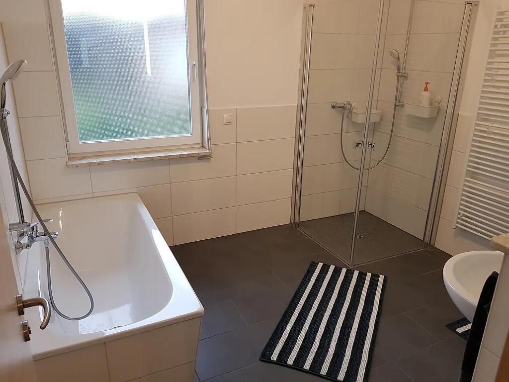 A bathroom with a bathtub, shower, and toilet.