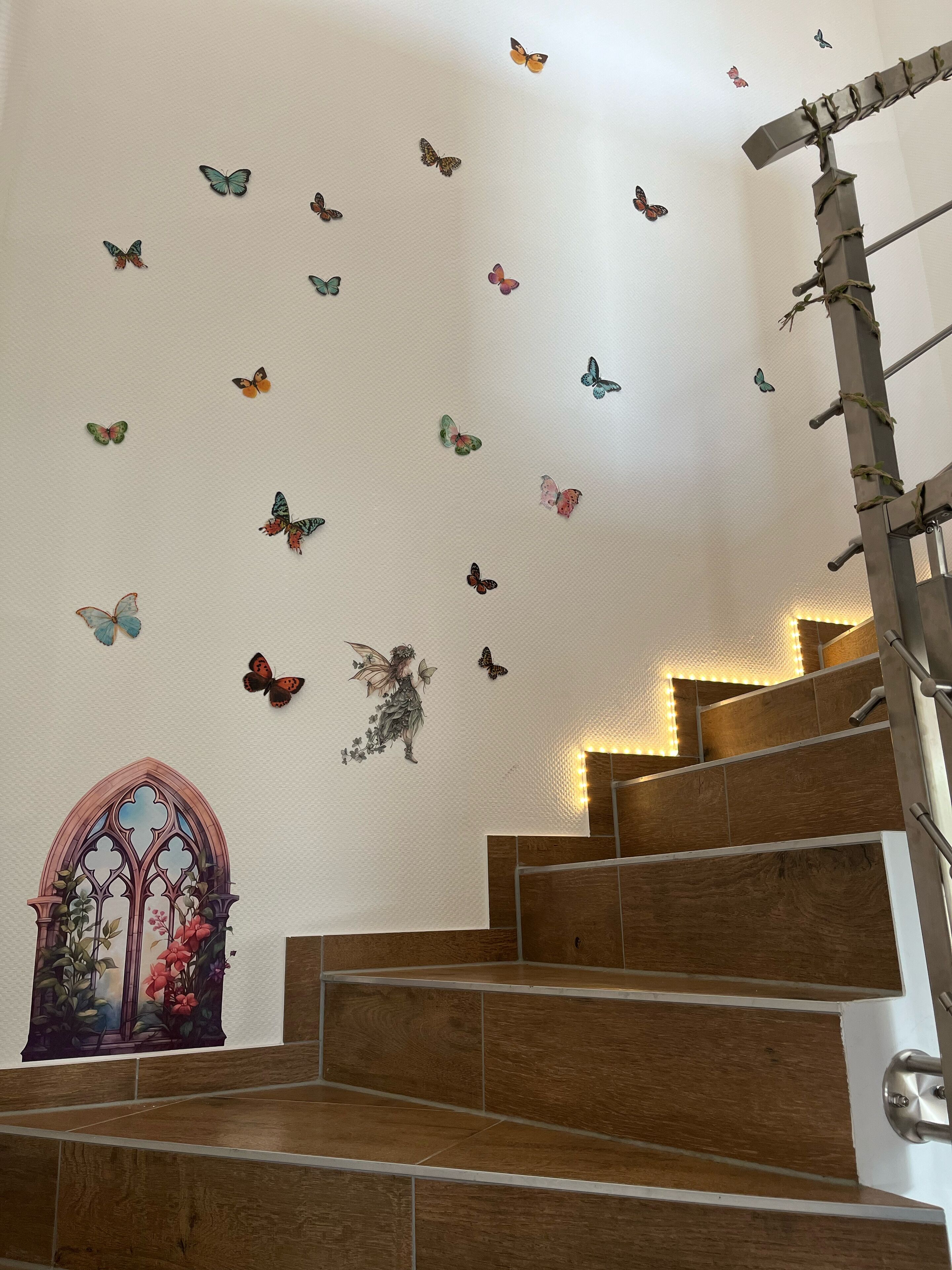 A staircase with wooden steps and a wall decorated with butterfly decals.