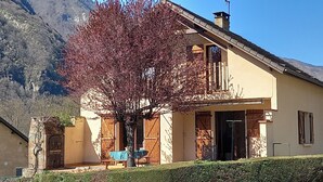 A two-story building with a balcony, a wooden door, and a window. - 4-bedroom villa, nature, quiet, panoramic mountain views (Salles-et-Pratviel (31110))