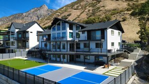 Ein modernes Mehrstöckhotel mit Poolbereich und Bergblick.