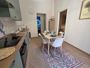 Une cuisine moderne avec un coin repas, un lave-linge et une horloge au mur.