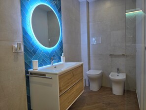 Een douche, een haardroger, een bidet, handdoeken