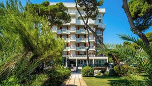 A multi-story hotel with balconies, surrounded by lush greenery and a clear sky. - Hotel Atlantic (Giulianova)