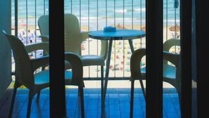 A balcony with a view of the ocean, a table, and chairs. - Hotel Atlantic (Giulianova)
