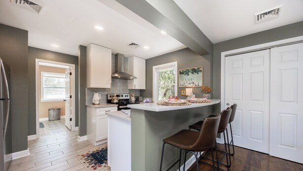 A modern kitchen with a central island, bar stools, and a view of the dining area. - Blue Lotus, LUXE Cottage, in walkable Kennett Square near Longwood Gardens (Kennett Square)
