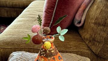 Un vaso decorativo con frutta e foglie su una superficie di legno strutturata.