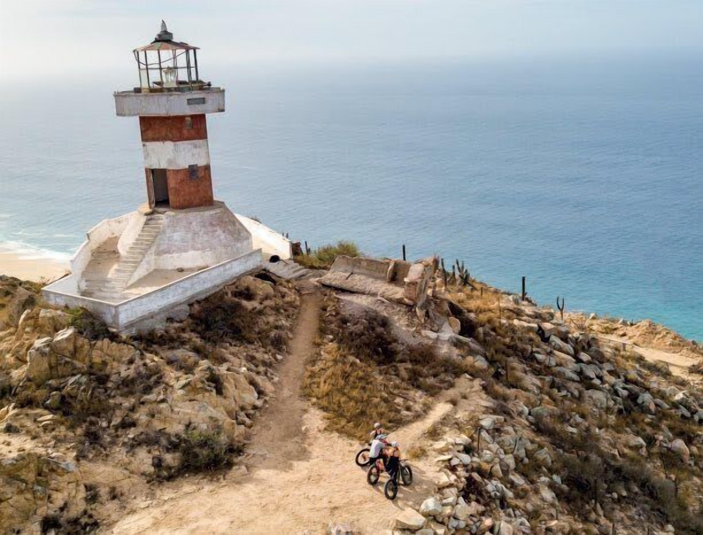 A lighthouse on a rocky cliff overlooking the sea.