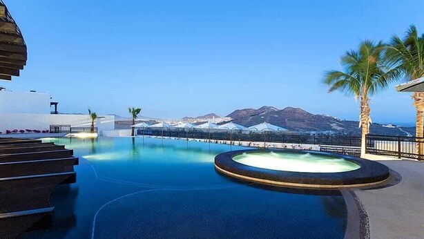 Un espace piscine offrant une vue sur les montagnes et un ciel dégagé.