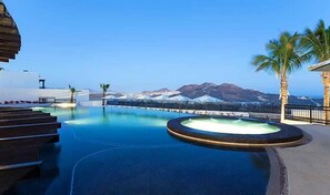 Un espace piscine offrant une vue sur les montagnes et un ciel dégagé.