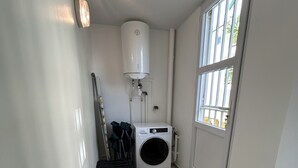 A laundry room with a washing machine, a dryer, a water heater, and a window. - 🏖️ Spacious 3-bedroom air-conditioned apartment with sea view in Pointe-à-Pitre (Pointe-à-Pitre)