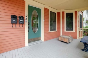 A house with a green door, a porch with a bench, and mailboxes on the side. - Classic charm with modern comforts near Harvard. (Cambridge)