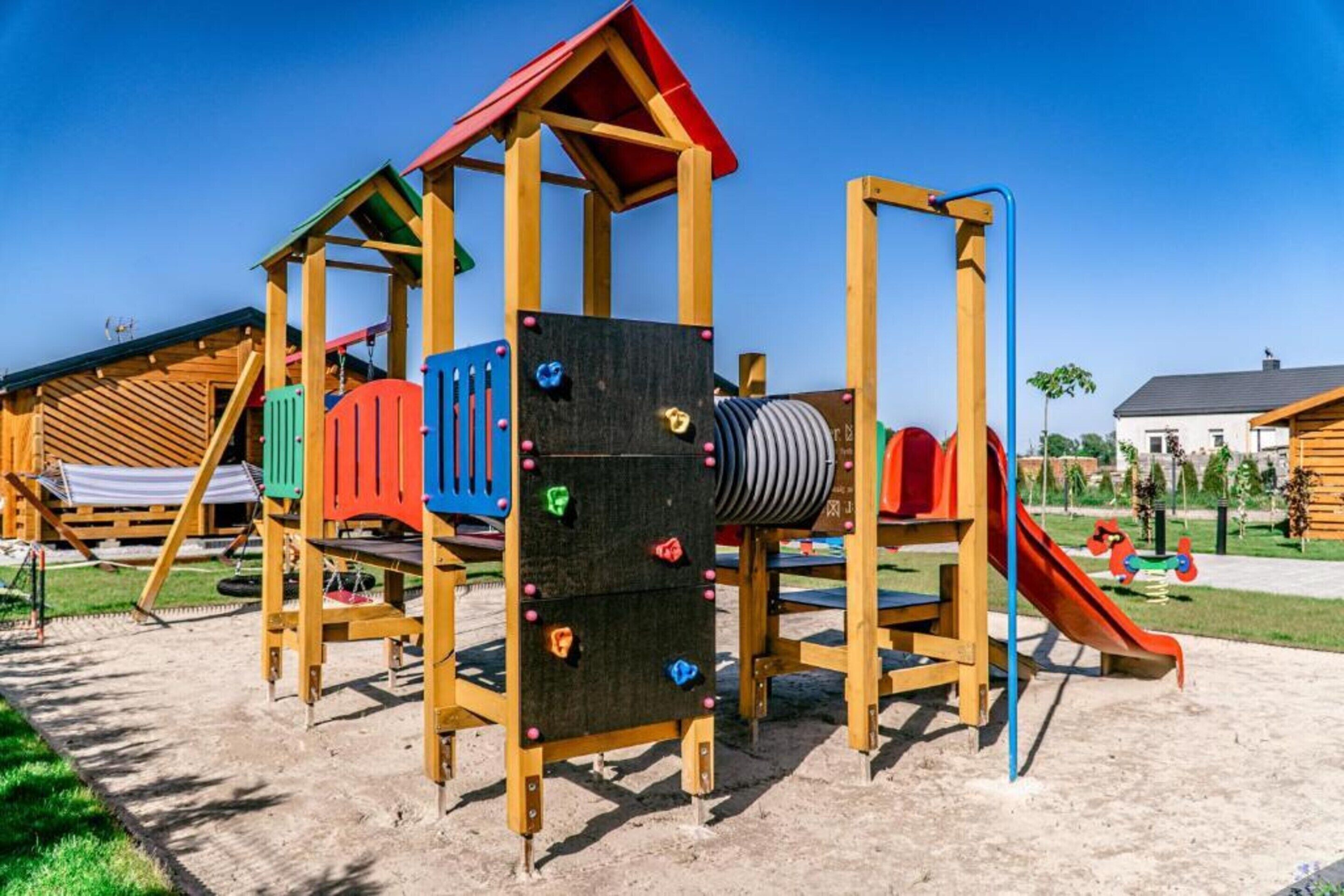 Un’area giochi con una parete da arrampicata, scivoli e altalene.