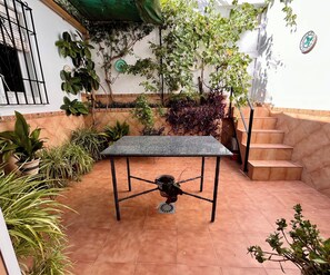 A courtyard with a table, potted plants, and a staircase. - Casa Vista Hermosa next to Natural Park - Sleeps 8 - Centro Andalucía (Rute)