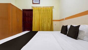 Una habitación de hotel con cama, armario y cortina.