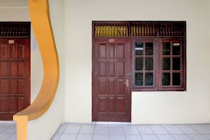 A building with a brown door and a window with multiple panes. - Hotel O Lowanu Stay Syariah (Yogyakarta)