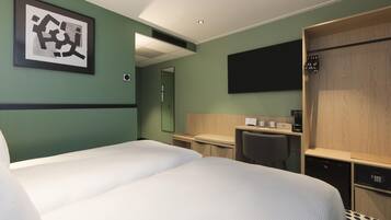 Une chambre d’hôtel équipée d’un lit, d’un bureau, d’une chaise, d’un miroir, d’une télévision et d’une armoire.