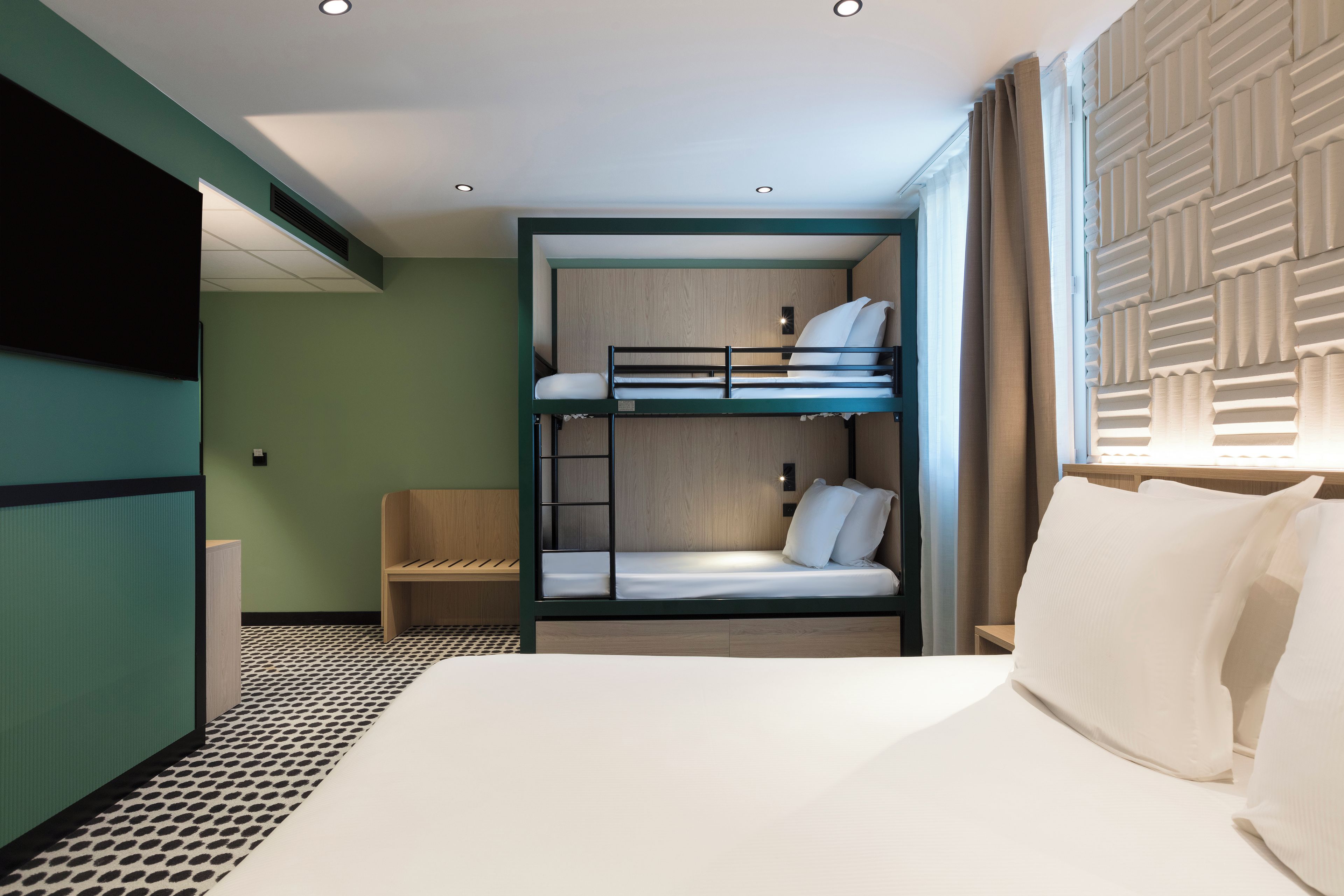 Habitación de hotel con literas, una cama individual, una silla y piso estampado.