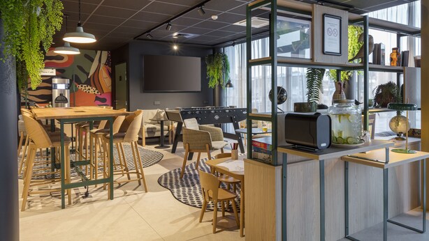 Un caffè moderno con un tavolo, sedie e un'area bar in legno.