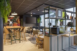 A modern cafe with a wooden table, chairs, and a bar area. - Best Western Marquise Cote D'Opale (Marquise)