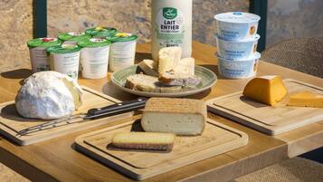 Une variété de fromages et de produits laitiers disposés sur une table en bois.