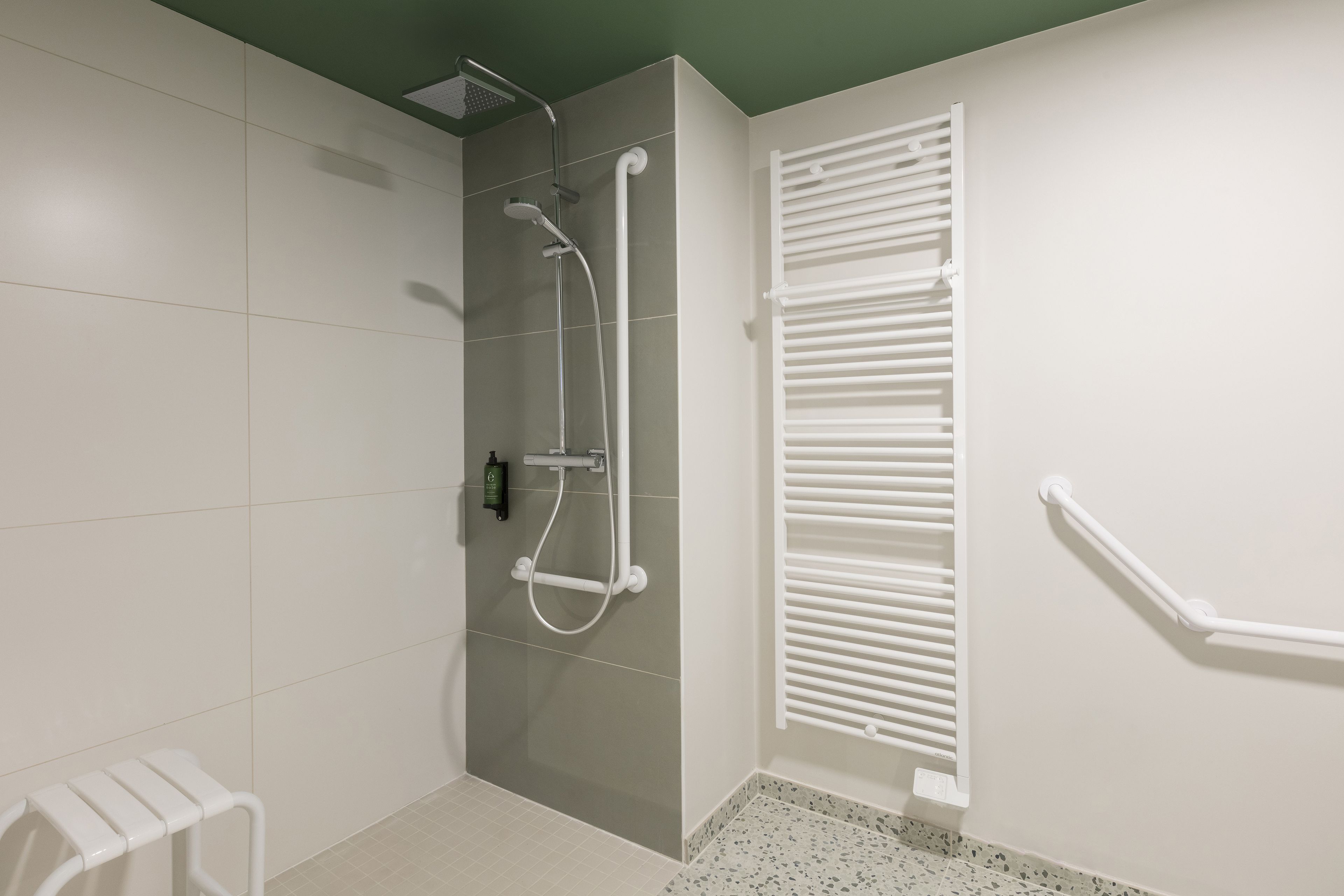 Une salle de bain avec une douche, des toilettes et un porte-serviettes.