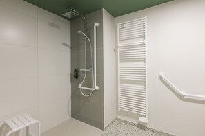 A bathroom with a shower, a toilet, and a towel rack.