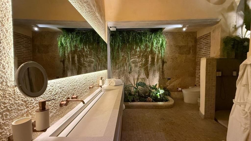 A bathroom with a large mirror, a bathtub, and a shower area.