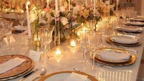 A long dining table set for a formal event with candles, floral centerpieces, and elegant tableware. - Hotel Casa Santiago Botero (Cartagena)