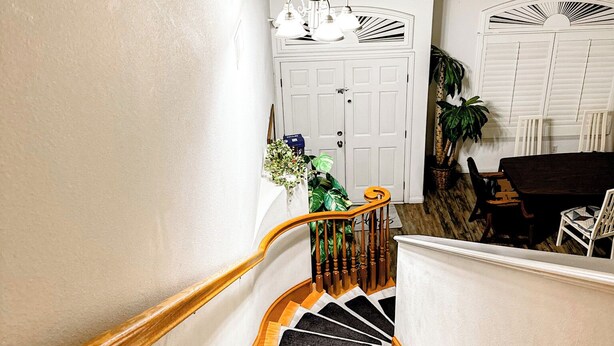 A staircase leading to a landing with a white door and a small window. - 2 separate bedroom private bathroom 20 mins from Disneyland btw LA, and OC (Artesia)