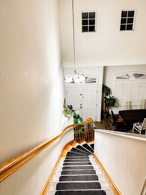A staircase leading to a landing with a white door and a small window. - 2 separate bedroom private bathroom 20 mins from Disneyland btw LA, and OC (Artesia)