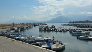 A marina with various boats docked, a clear sky, and distant mountains. - Marèa - Holiday House (Porticello)