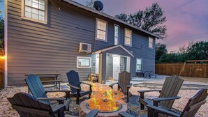 A house with a fire pit in the backyard, surrounded by Adirondack chairs. - 2BR Houston Haven, Playground, Prime Location (Houston)