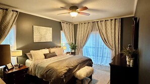 A bedroom with a bed, a ceiling fan, a nightstand, a lamp, and a dresser. - Beautiful 4 bedroom Country Estate in Liberty. Minutes from downtown KC. (Liberty)