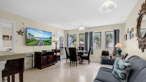 A living room with a TV, dining area, and a sofa.