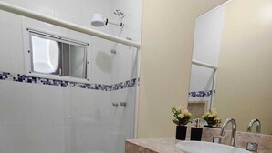 A modern bathroom with a shower, toilet, and sink. - CASA FLORENÇA (Indaiatuba)