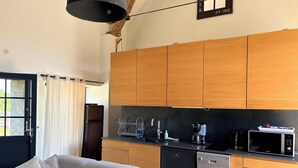 Une cuisine compacte avec des meubles en bois, un lave-vaisselle intégré et un four à micro-ondes.