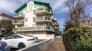 A multi-story building with balconies and a car parked in front. - Emerald apartment with beach access in Pereire (Arcachon)