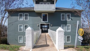 A two-story house with a front entrance, a balcony on the upper floor, and a gated driveway. - Ridge Retreats Unit B - Balcony/Wifi/4 Queen Beds (Birmingham)