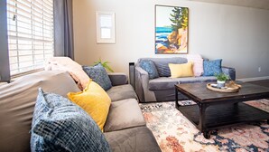 Ein Wohnzimmer mit einer Couch, einem Couchtisch und einem Bild an der Wand.