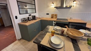 Een moderne keuken met een houten aanrecht, een ingebouwde oven en een groot raam boven de gootsteen.
