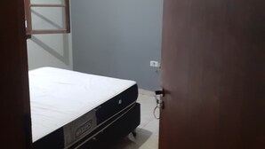 Un dormitorio con literas, un cuadro en la pared y un enchufe.