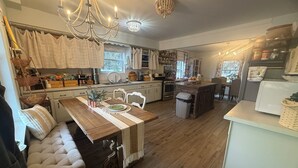 Una cocina acogedora con una mesa de madera, un banco y una araña.