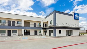 A modern hotel with a flat roof, a sign indicating it is a Best Value Inn & Suites, and a parking lot with marked spaces. - Americas Best Value Inn & Suites Tomball Grand Parkway (Tomball)