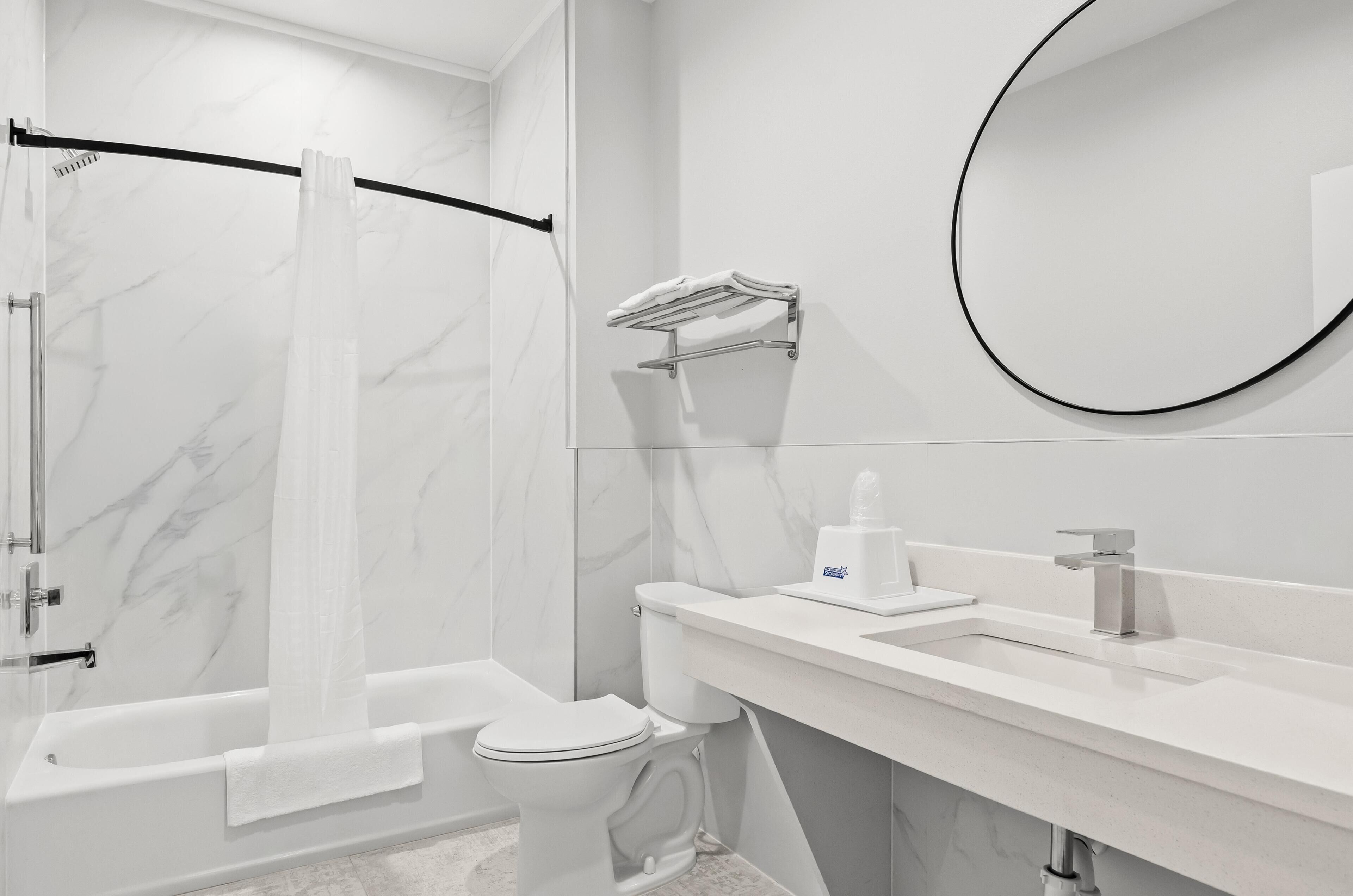 Un baño moderno con ducha, inodoro y lavamanos.