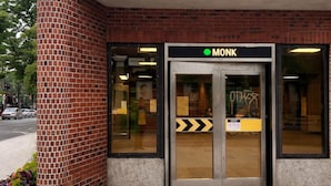 Ein Backsteinhaus mit Glastür, auf der „MONK“ steht.