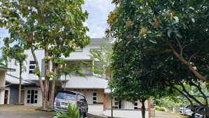 A residential area with a paved driveway, parked cars, and mature trees. - Hotel O House Of Fosil Syariah (Semarang)