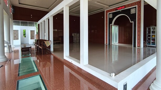 A spacious lobby with a polished floor, a reception desk, and a large glass door leading to the entrance. - Hotel O House Of Fosil Syariah (Semarang)