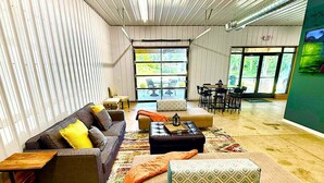 A spacious room with a sofa set, a coffee table, and a dining area with chairs. - Huron Hideaway - Great Indoor & Outdoor Spaces! (Huron)