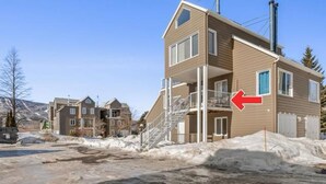 A two-story residential building with a balcony, a chimney, and a snow-covered ground. - Condo MSA - Ski Beaupré (Beauprã©)